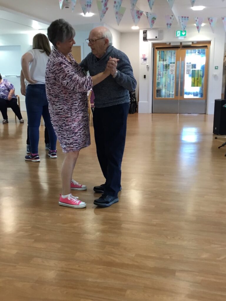 two residents dancing together in a local town hall
