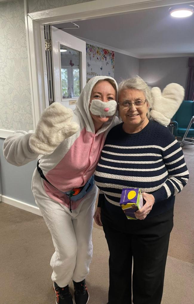 staff dressed up for easter with resident and a easter egg