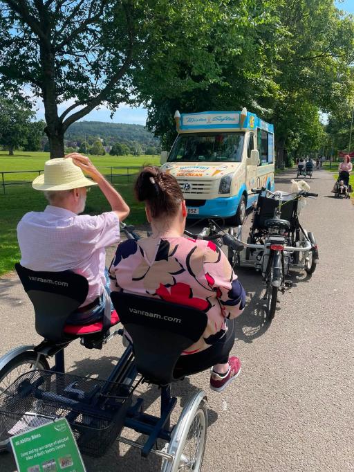 resident and carer cycling in park