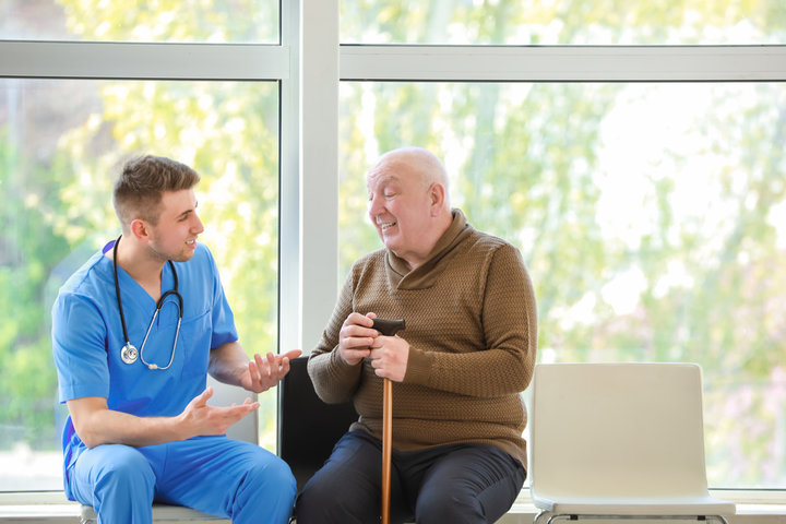 resident and nurse speaking and smiling in care home
